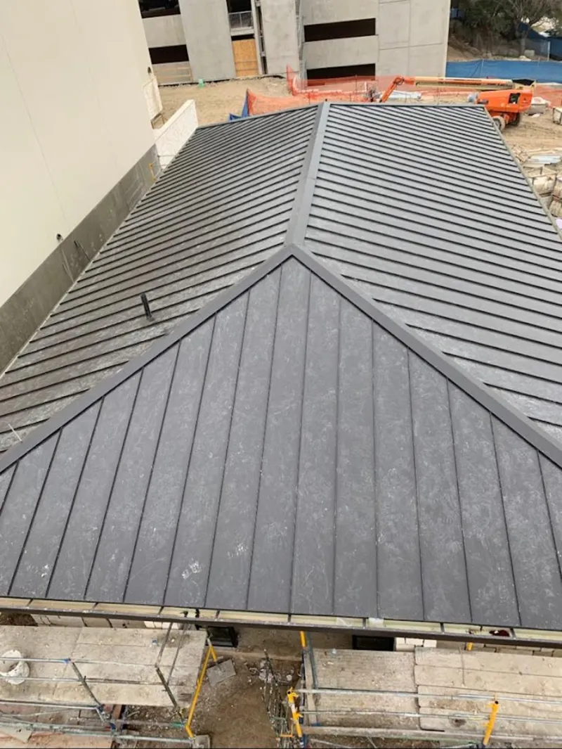 Commercial metal roof construction with crane equipment in St. James